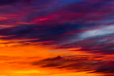 Tramonto infuocato con vetta all'orizzonte