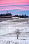 Colline innevate, tramonto rosa, chiesa a cupola