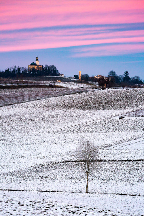 Colline innevate, tramonto rosa, chiesa a cupola, fotografia di Anne Conway — MonferrArte